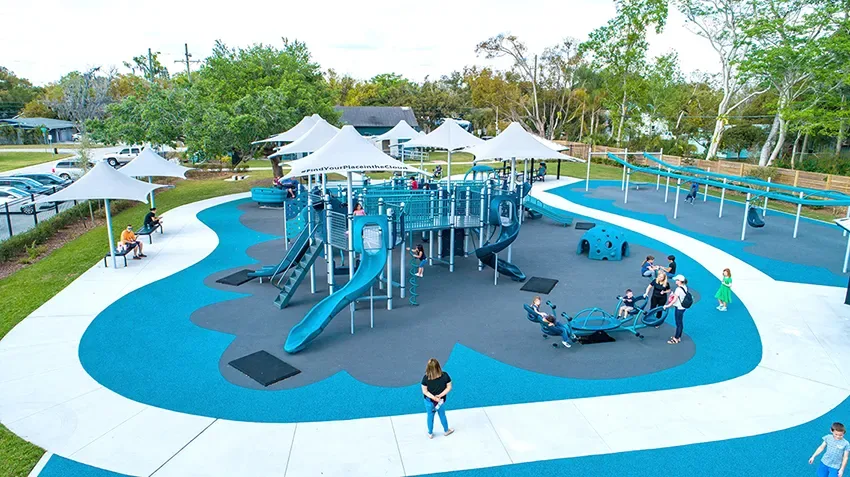 Playground a céu aberto com piso emborrachado com escorregadores e balanços
