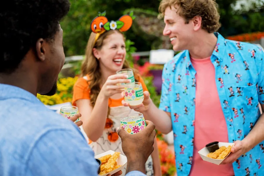 Amigos degustam bebidas e pratos durante o festival de flores da Disney
