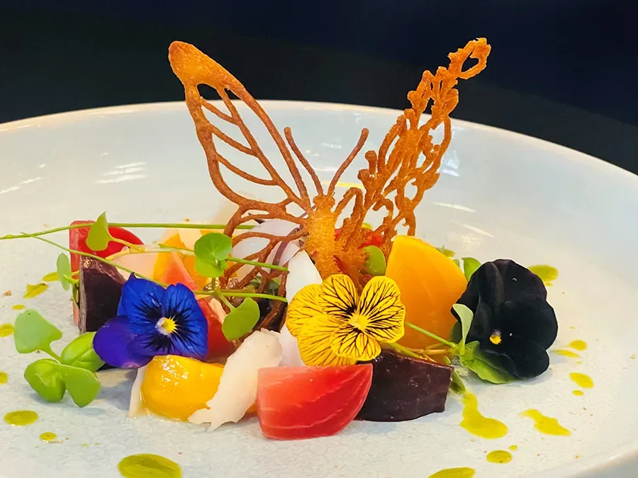 Prato com peixes, frutas e flores comestíveis com ornamento de borboleta