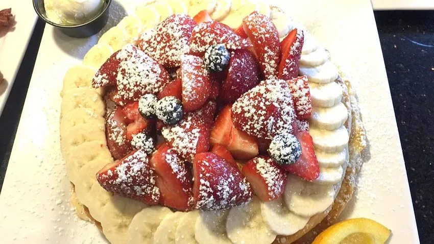 Pratos de panquecas w waffles de morango com banana servidos no Keke's Breakfast Café em Orlando, na Flórida