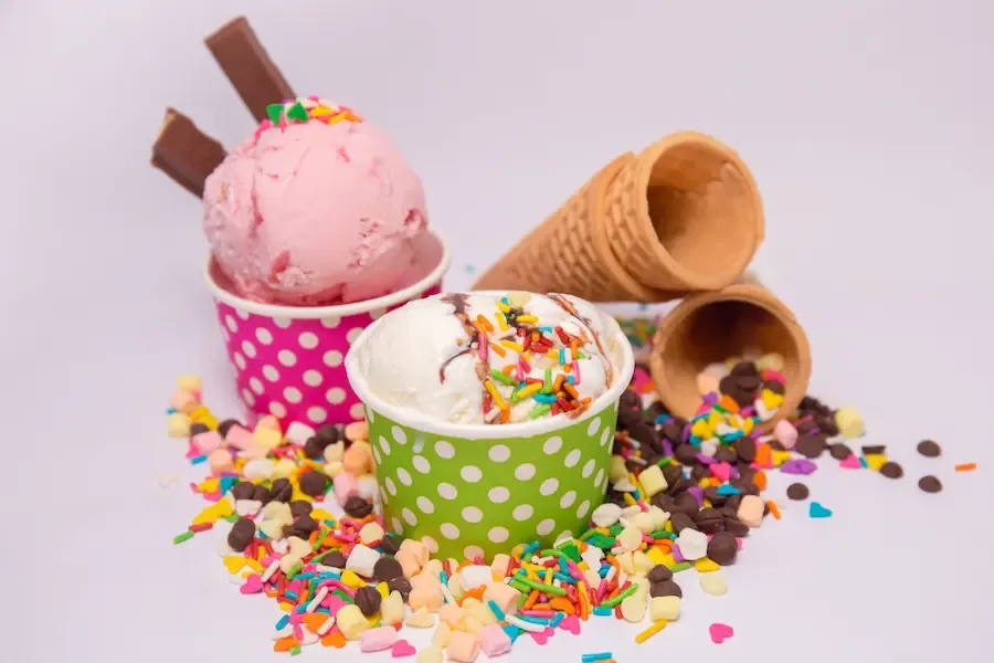 Copos e cones de sorvetes com granulados e chocolates