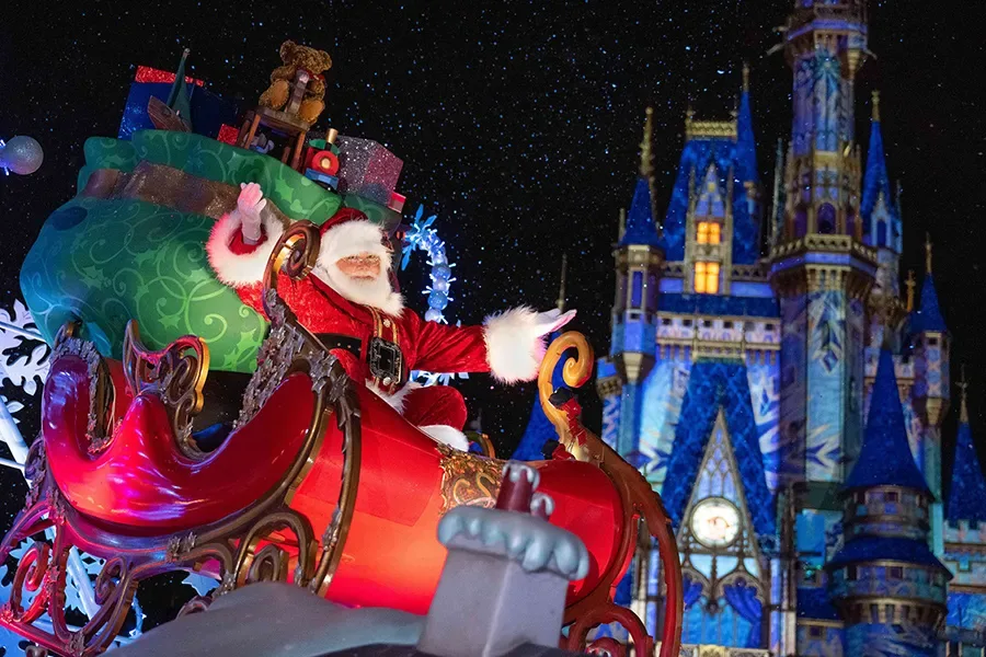 Papai Noel acena para visitantes em cima de um carro alegórico em frente ao castelo da Cinderela no Magic Kingdom