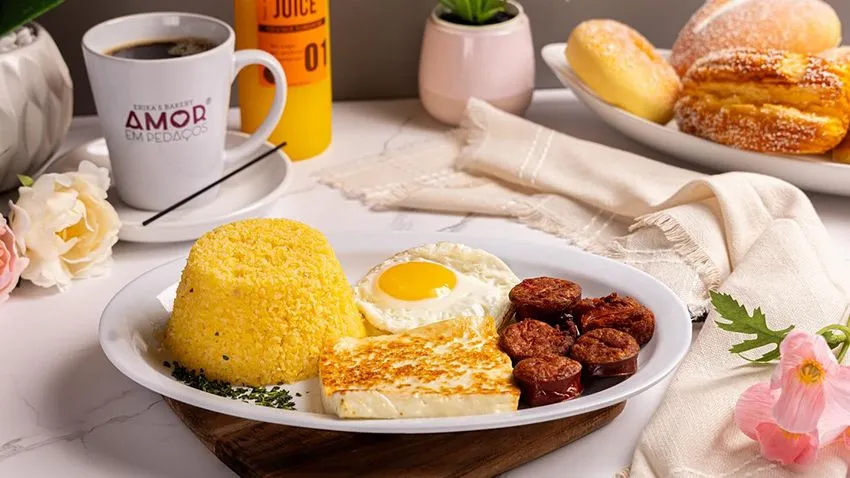Mesa mostra a variedade de opções do café da manhã da Amor em Pedaços Bakery, em Orlando, com ovos, pães, bacon e café