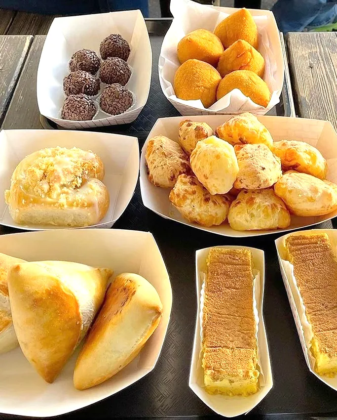 Mesa de café da manhã da Gostoso Bakery, em Orlando, com coxinhas, pães de queijo, salgados e brigadeiros