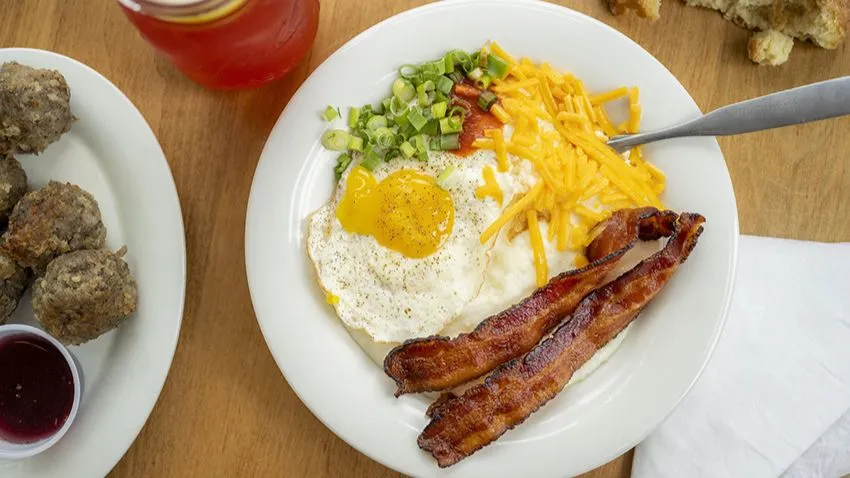 Prato de café da manhã do Maple Street Biscuit, em Orlando, com um generoso prato de ovos fritos com bacon