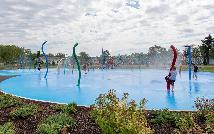 Parque em Capehart Park com splash pad onde crianças brincam na água