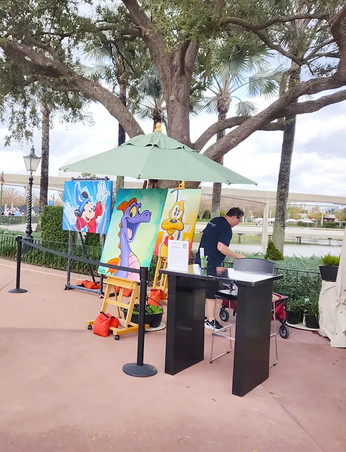 Artista expondo suas obras de arte inspiradas em personagens da Disney no World Showcase do EPCOT